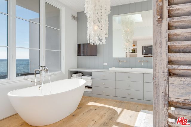 a bathroom with a bathtub and double sink