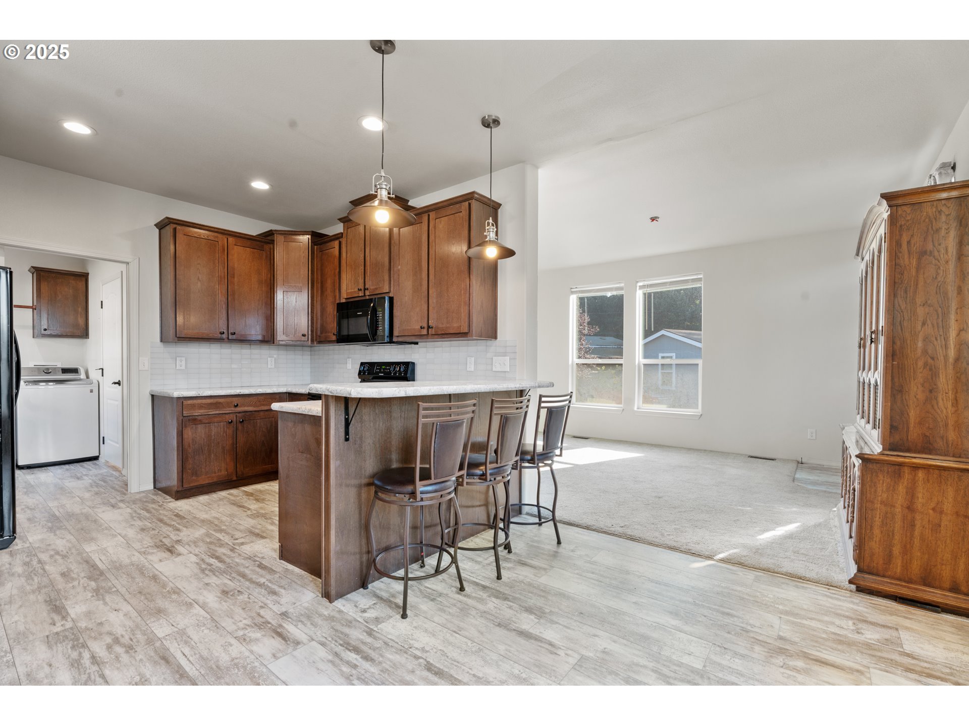 9700 Southwest Tualatin Road, Unit 9 Tualatin, OR 97062 - Photo 5 of 18 a kitchen with kitchen island granite countertop a stove top oven a sink a dining table and chairs
