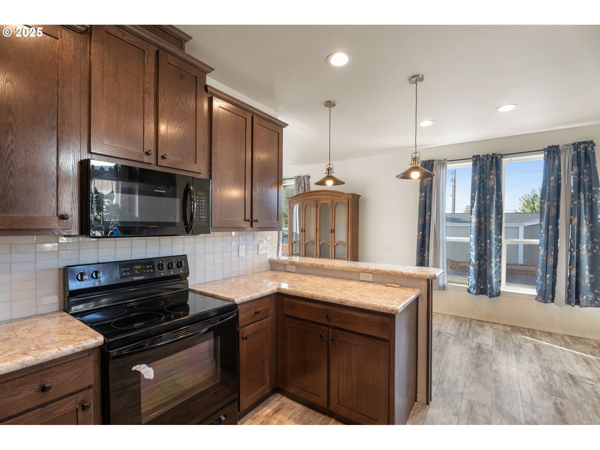9700 Southwest Tualatin Road, Unit 9 Tualatin, OR 97062 - Photo 6 of 18 a kitchen with stainless steel appliances kitchen island granite countertop a stove a sink and a microwave