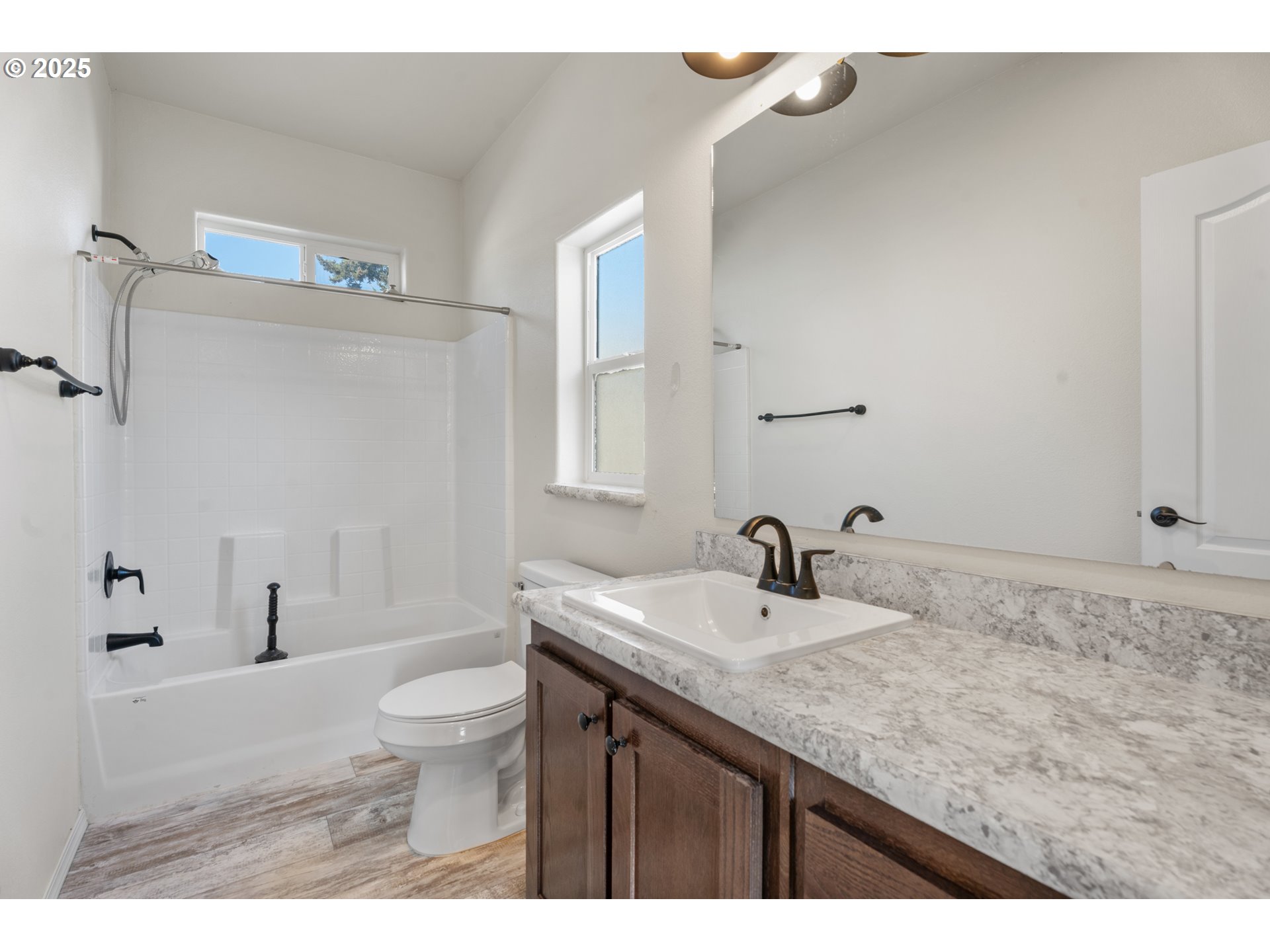 9700 Southwest Tualatin Road, Unit 9 Tualatin, OR 97062 - Photo 8 of 18 a bathroom with a granite countertop sink a toilet a mirror and shower