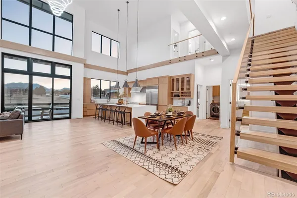 a dining room with furniture a chandelier and wooden floor
