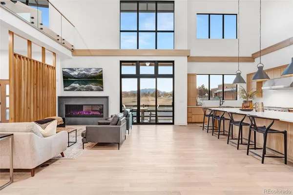 a living room with furniture a fireplace and a large window