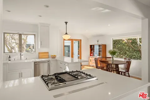 a kitchen with a stove a sink a dining table and chairs