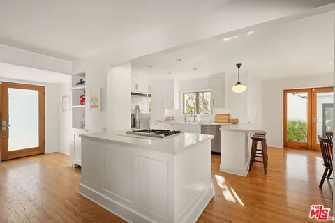 a kitchen with a sink cabinets and wooden floor
