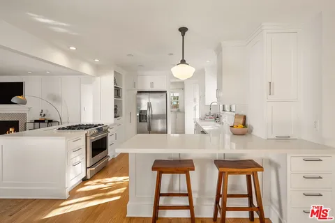 a kitchen with stainless steel appliances granite countertop a stove a sink dishwasher and a refrigerator with wooden floor