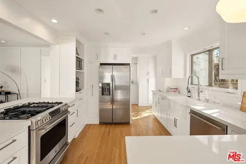 a kitchen with stainless steel appliances granite countertop a sink stove and refrigerator