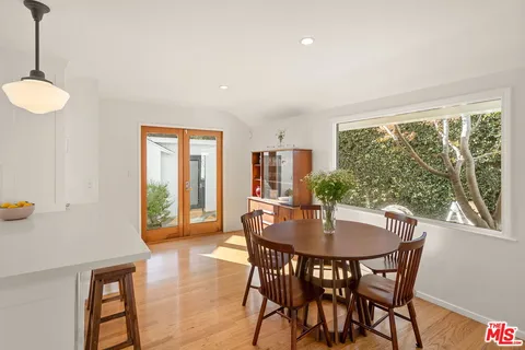a dining room with furniture window and wooden floor