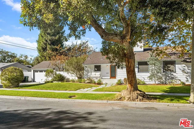a view of a house with a big yard and large trees