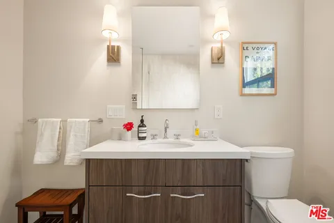 a bathroom with a sink vanity mirror and toilet