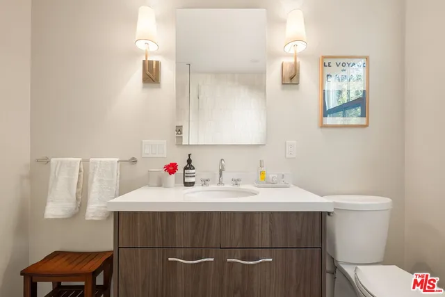 a bathroom with a sink vanity mirror and toilet