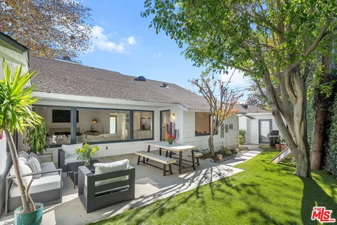 a view of a house with backyard and sitting area