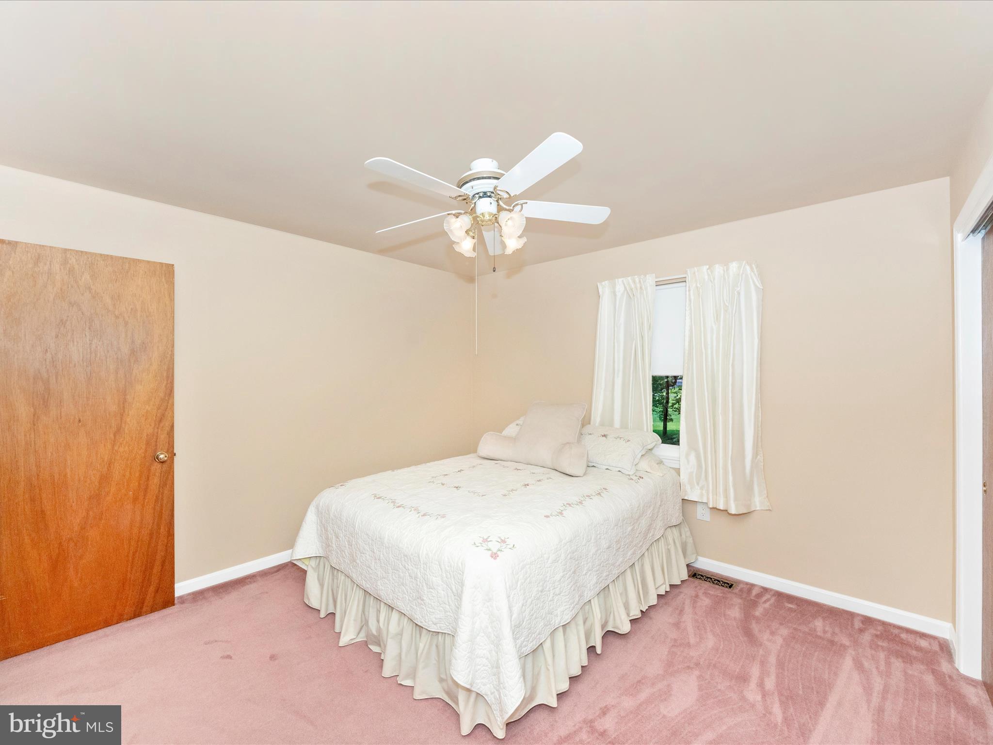 3180 Hunting Creek Road Huntingtown, MD 20639 - Photo 31 of 55 a spacious bedroom with a bed and a chandelier