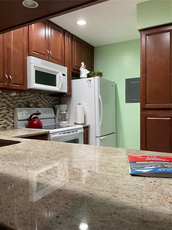 2655 Pine Ridge Way North, Unit D3 Palm Harbor, FL 34684 - Photo 10 of 31 a kitchen with stainless steel appliances kitchen island granite countertop a refrigerator stove and sink