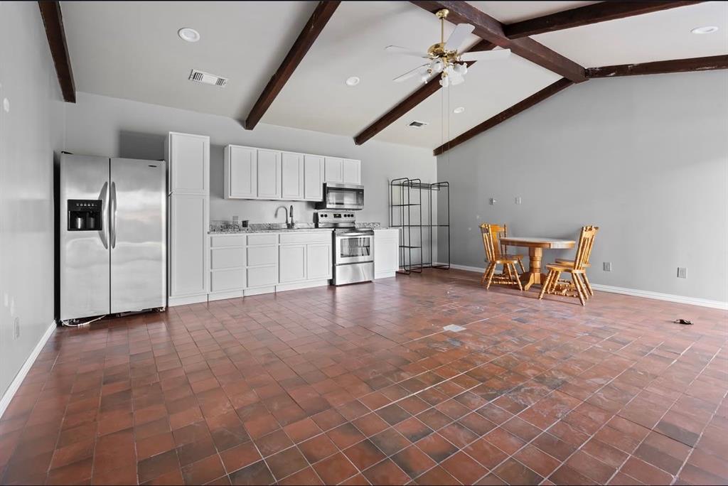a view of a kitchen with refrigerator and chairs