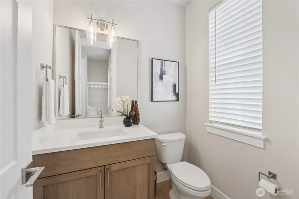 a bathroom with a sink a toilet a mirror and shower