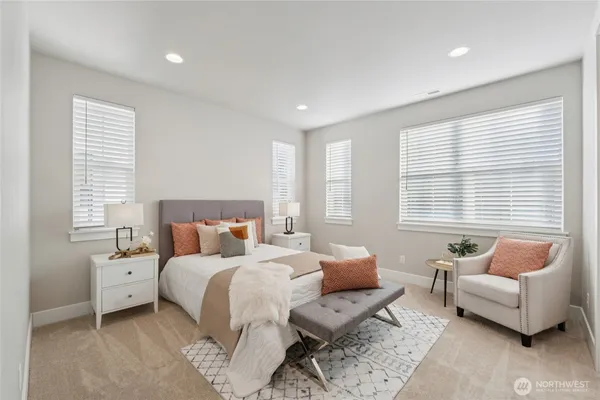 a bedroom with a bed and a couch with windows