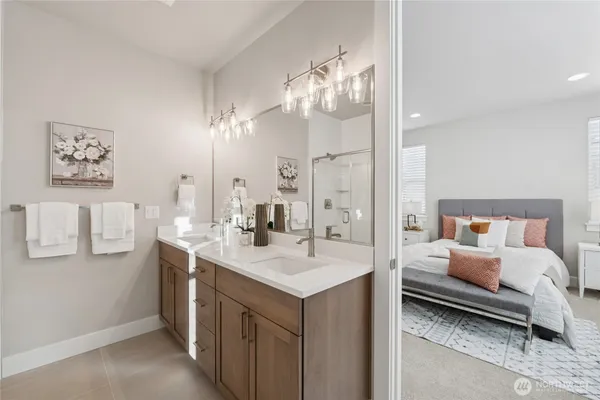 a en suite bathroom with a sink double vanity and a mirror