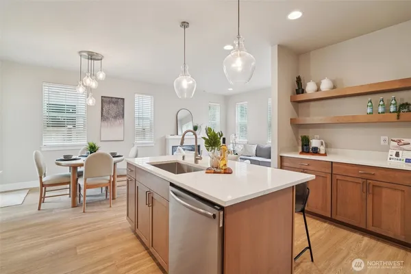 a kitchen with a dining table chairs sink and cabinets