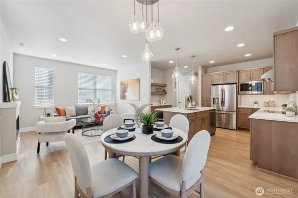 a view of a dining room and livingroom with furniture wooden floor a chandelier