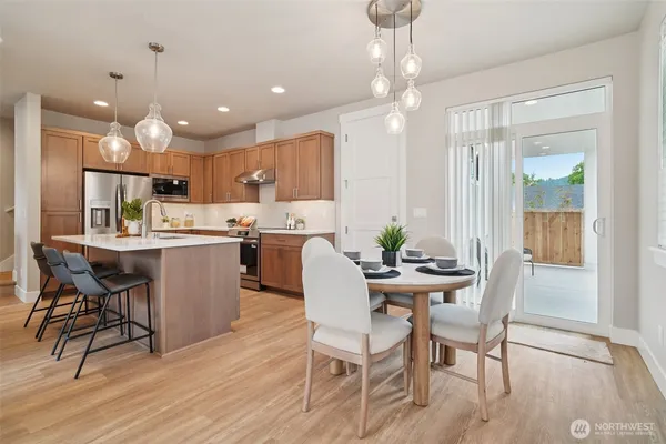 a view of a dining room and livingroom with furniture wooden floor a chandelier