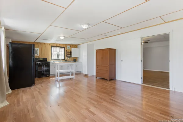 a view of a kitchen with wooden floor and electronic appliances
