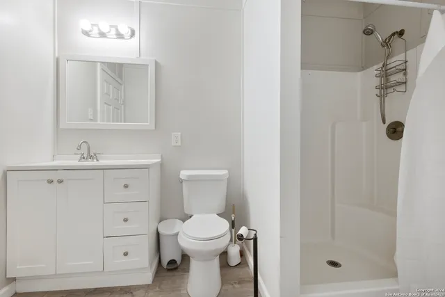 a bathroom with a toilet sink vanity and mirror