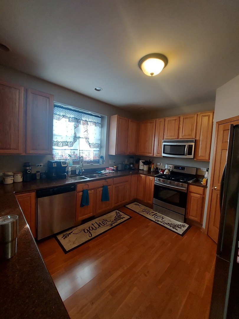 1022 Eineke Boulevard, Unit 1022 Algonquin, IL 60102 - Photo 4 of 18 a kitchen with stainless steel appliances granite countertop a stove a sink and a microwave