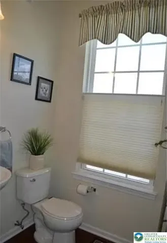a bathroom with a toilet a sink and a mirror