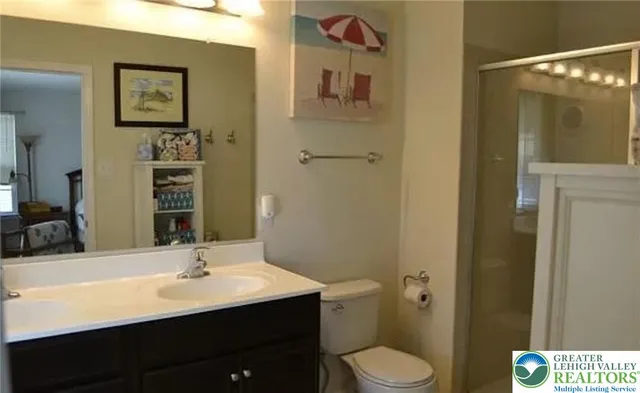 a bathroom with a toilet sink a mirror and vanity