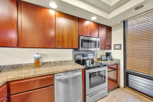 a kitchen with stainless steel appliances granite countertop a sink stove and cabinets
