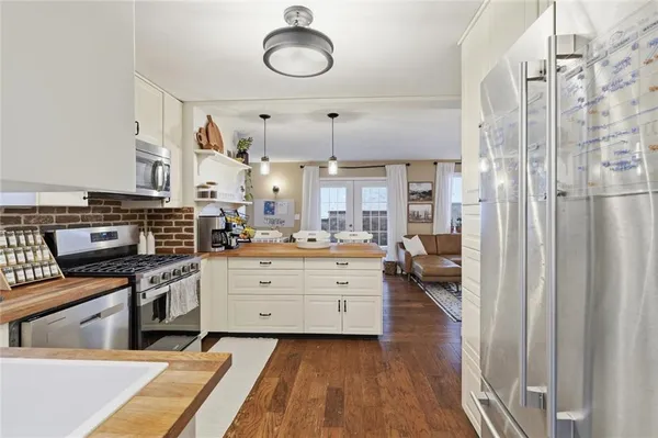 a kitchen with stainless steel appliances kitchen island granite countertop a stove a sink and a refrigerator