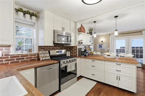 a kitchen with appliances a sink and a window
