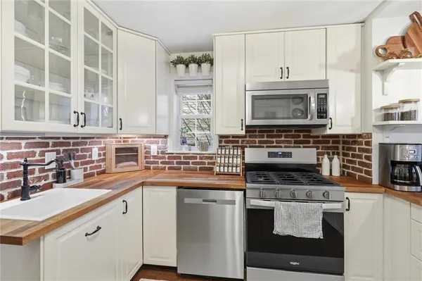 a kitchen with cabinets appliances a sink and a counter top space