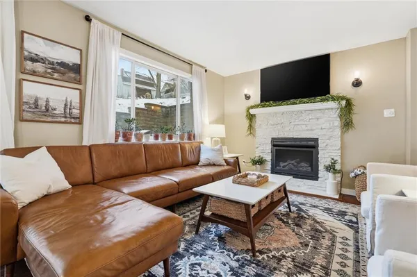 a living room with furniture a flat screen tv and a fireplace