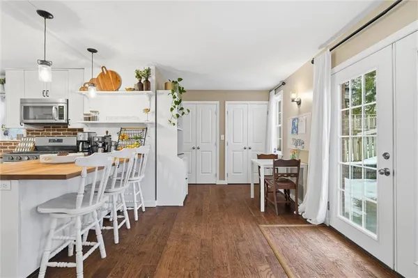 a living room with stainless steel appliances kitchen island granite countertop furniture and a wooden floor