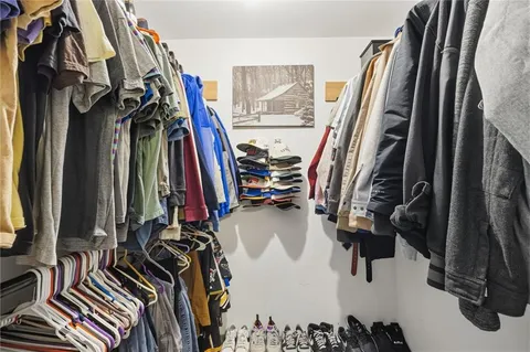 a view of walk in closet with clothes and shoes