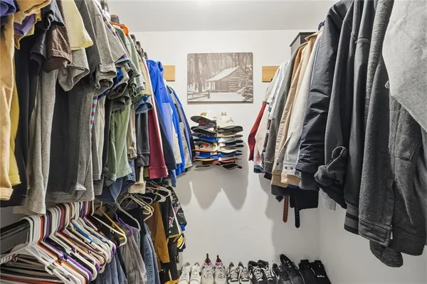 a view of walk in closet with clothes and shoes