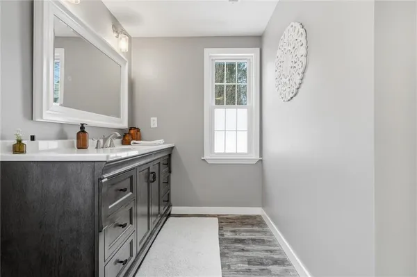 a bathroom with a sink a mirror and a window