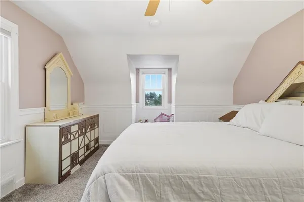 a bedroom with a bed a mirror and a dresser