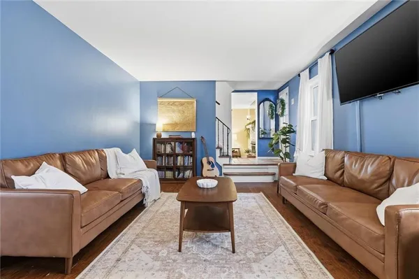 a living room with furniture a flat screen tv and a large window