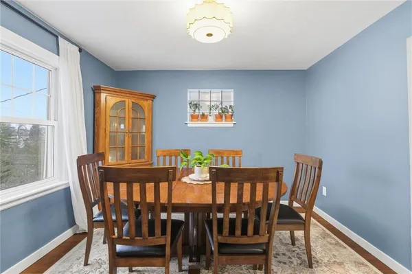 a view of a dining room with furniture a rug and wooden floor