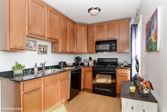 2448 West Addison Street, Unit OB Chicago, IL 60618 - Photo 2 of 5 a kitchen with stainless steel appliances granite countertop a stove a sink and a microwave