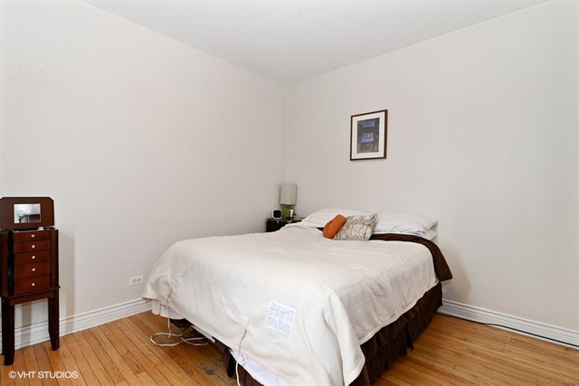 2448 West Addison Street, Unit OB Chicago, IL 60618 - Photo 5 of 5 a bedroom with a bed and wooden floor
