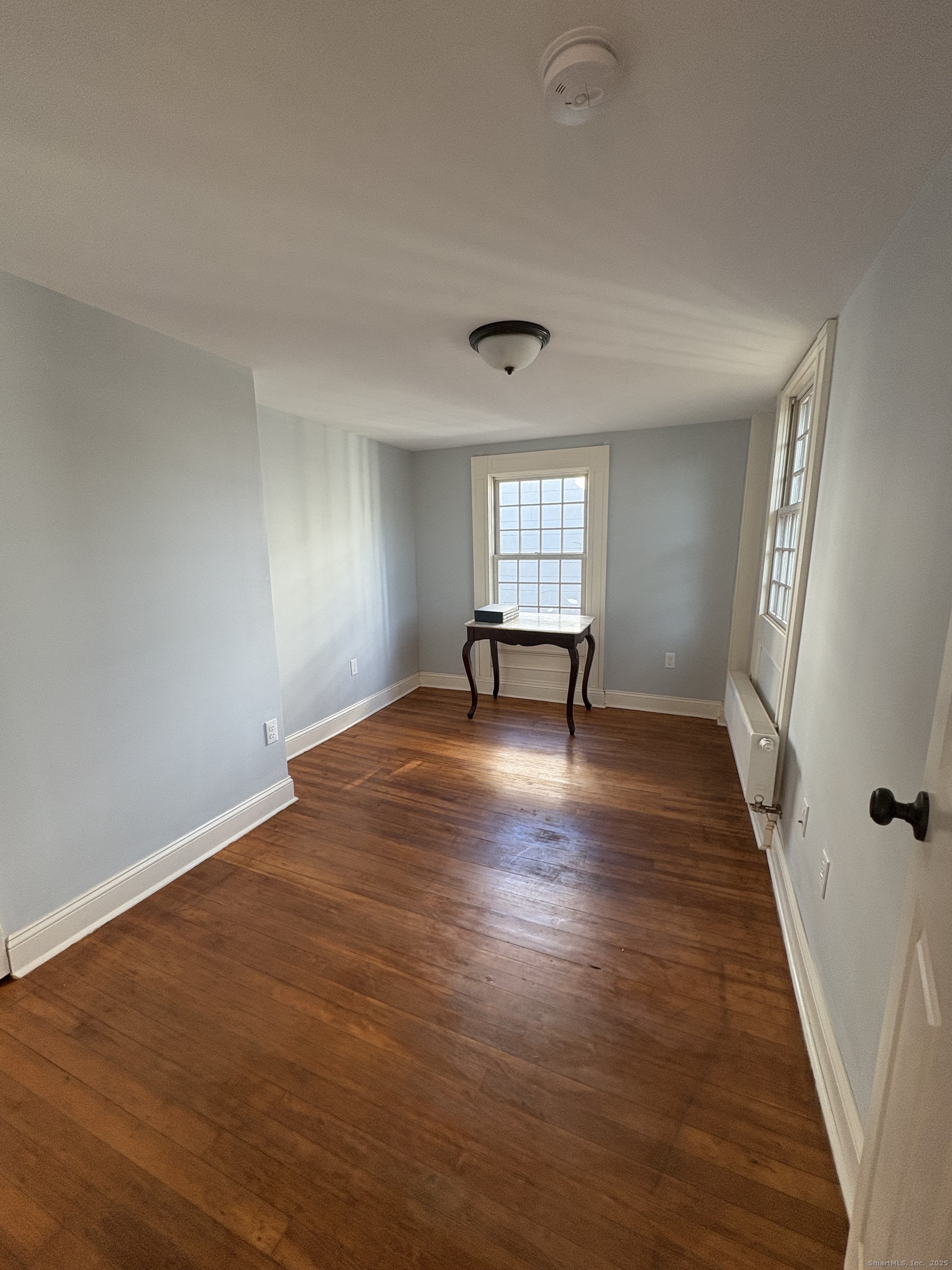 7 Coit Street, Unit 2 New London, CT 06320 - Photo 15 of 19 an empty room with wooden floor and windows