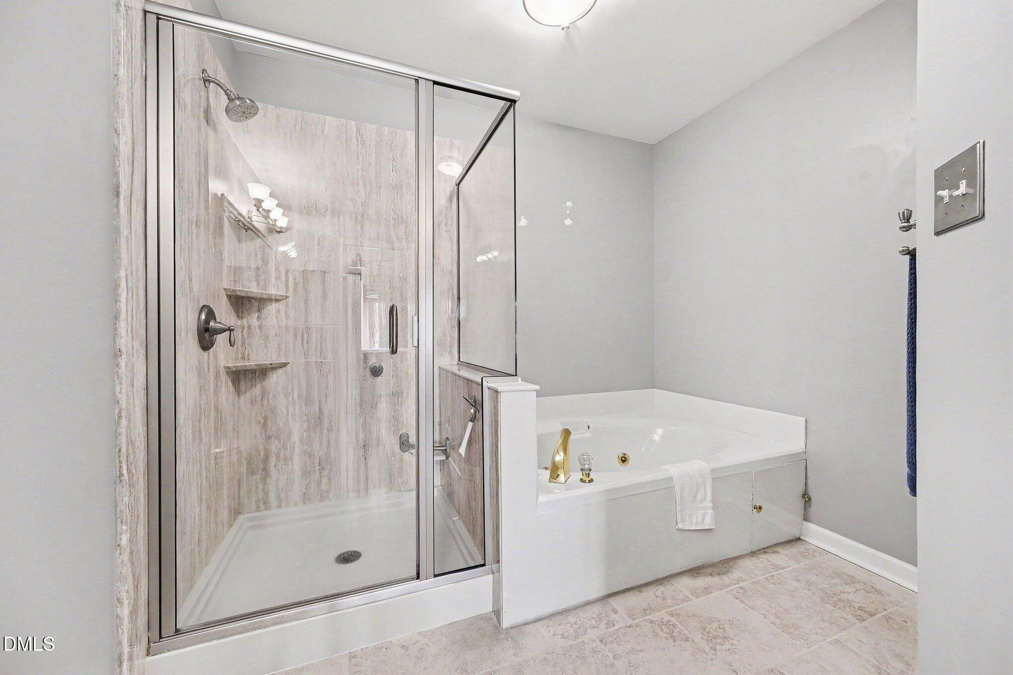 132 Springfork Drive Cary, NC 27513 - Photo 21 of 28 a bathroom with a bathtub and a shower