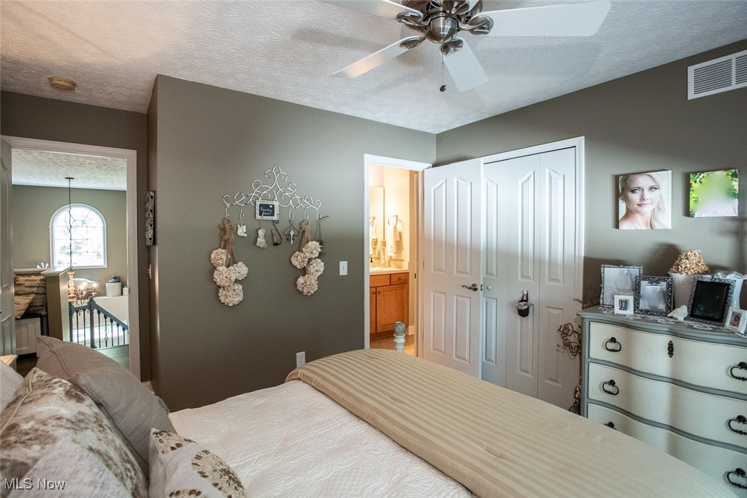632 Rundle Street Lagrange, OH 44050 - Photo 26 of 30 Bedroom featuring a textured ceiling, a chandelier, a ceiling fan, and a closet