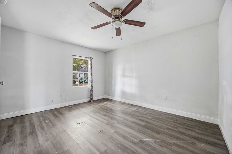 12659 Chiswick Road Houston, TX 77047 - Photo 12 of 21 an empty room with wooden floor and windows