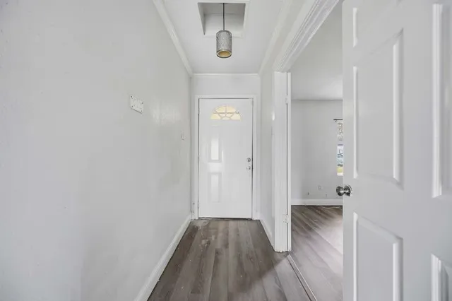a view of a hallway with wooden floor and staircase