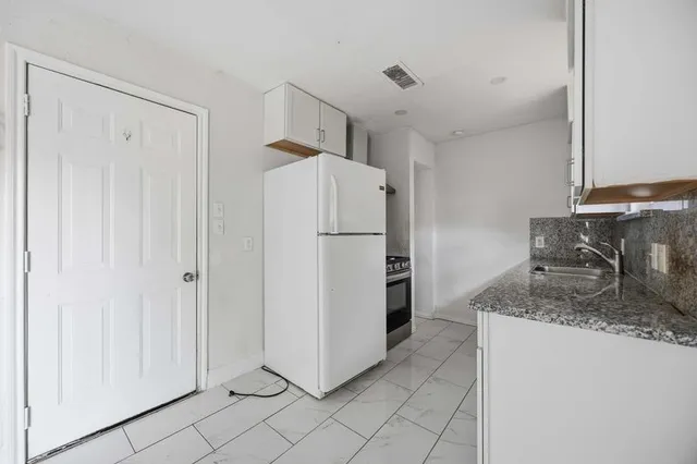 a kitchen with stainless steel appliances granite countertop a refrigerator and a sink