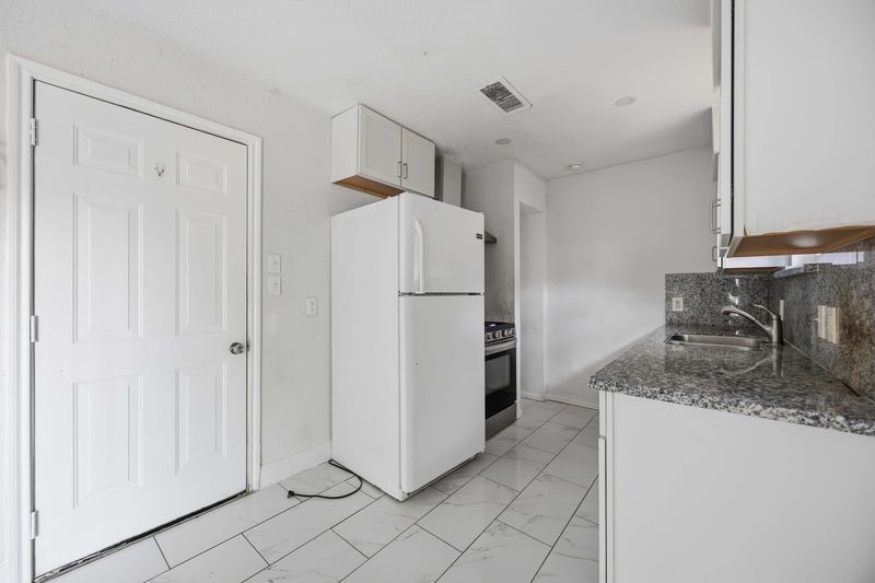 12659 Chiswick Road Houston, TX 77047 - Photo 6 of 21 a kitchen with stainless steel appliances granite countertop a refrigerator and a sink